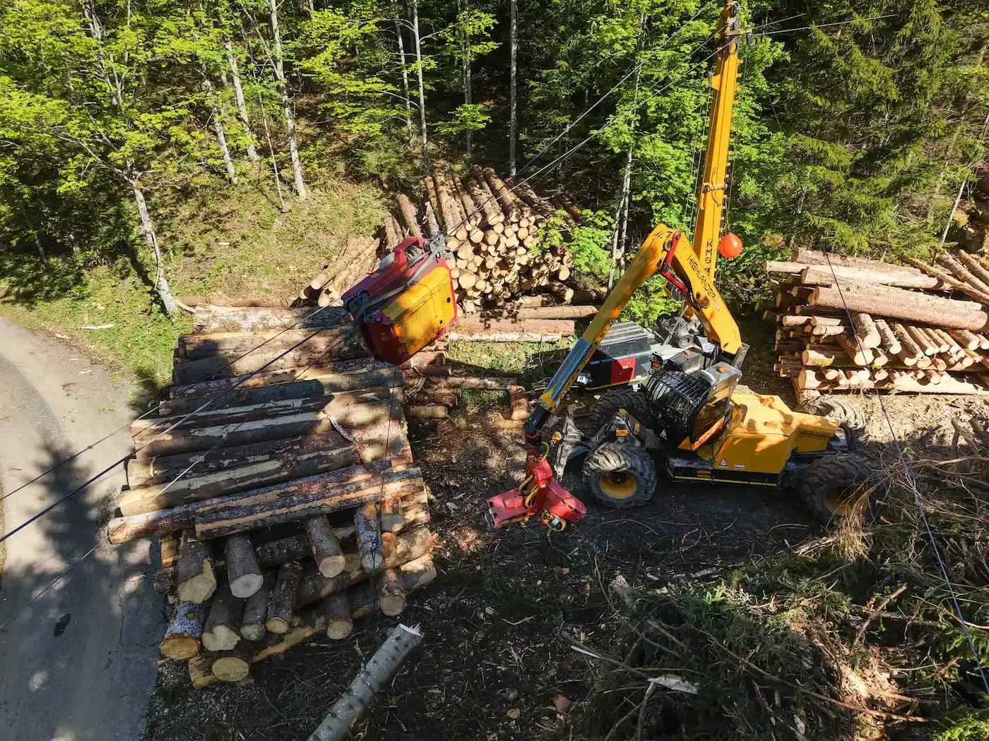 Seilkran und Rückefahrzeug beim Aufrüsten von Rundholz am Waldrand